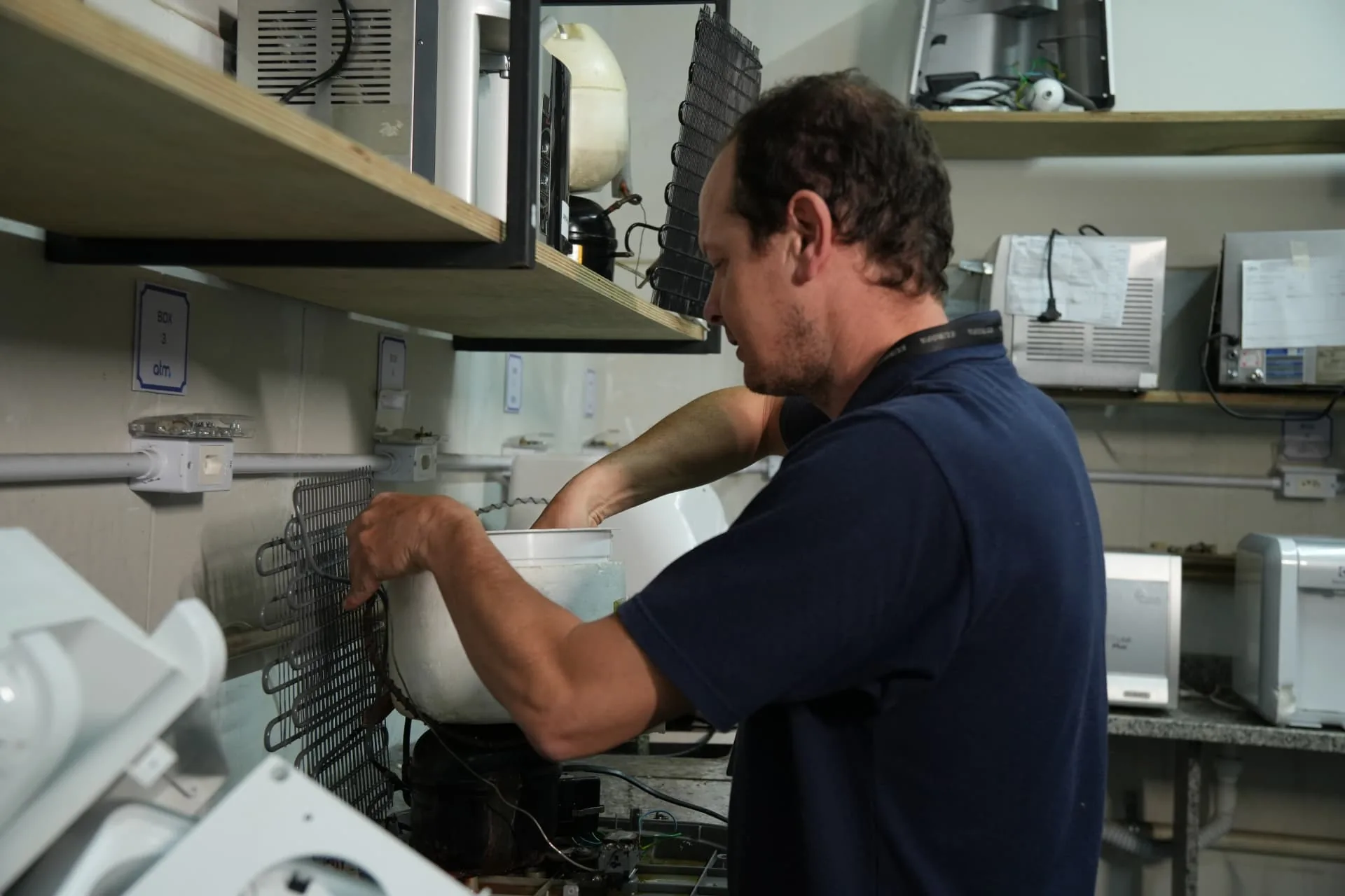 Técnico da ATM realizando manutenção de purificador na bancada da assistência em Itajaí