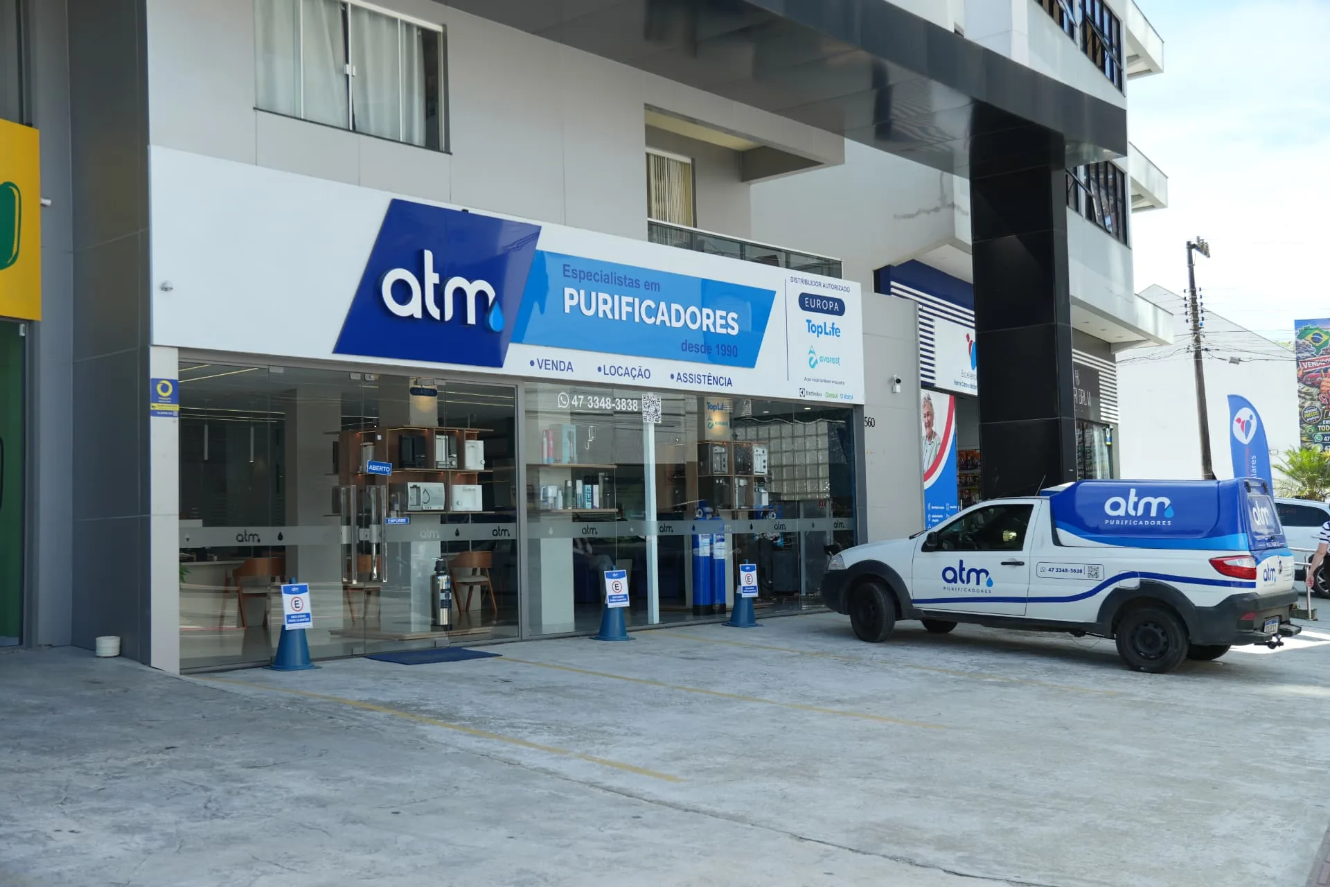 Fachada da loja ATM Purificadores em Itajaí com veículo de atendimento próprio estacionado